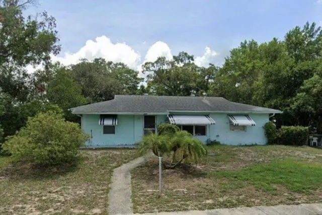 Dated block home with a worn yard